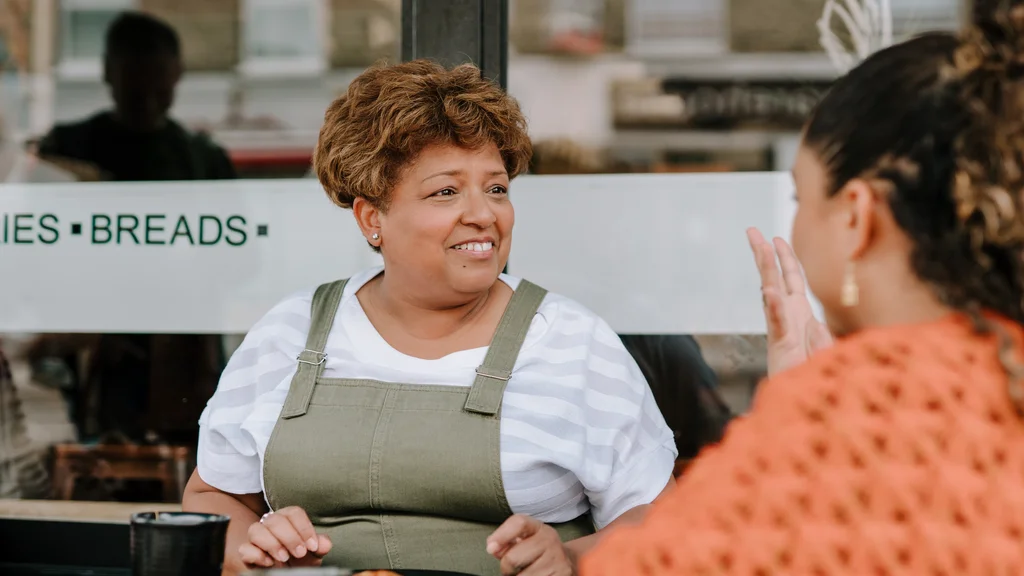 Two women talking outside at a cafe