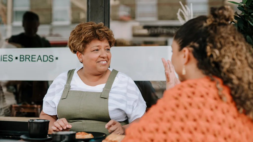 Two women talking outside at a cafe