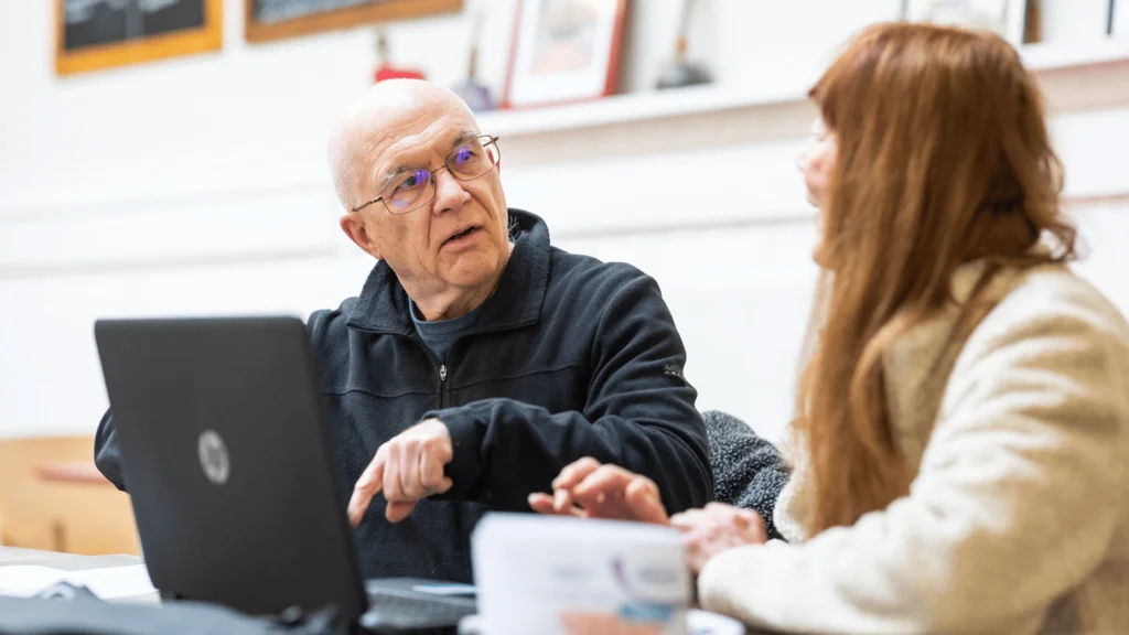 Two people using a laptop