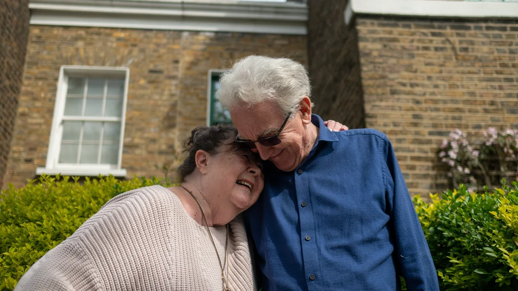 An older couple hugging outside