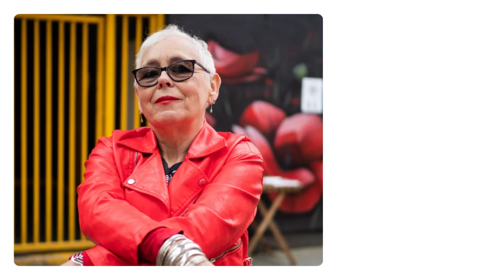 A woman wearing a red leather jacket, silver bracelets and sunglasses